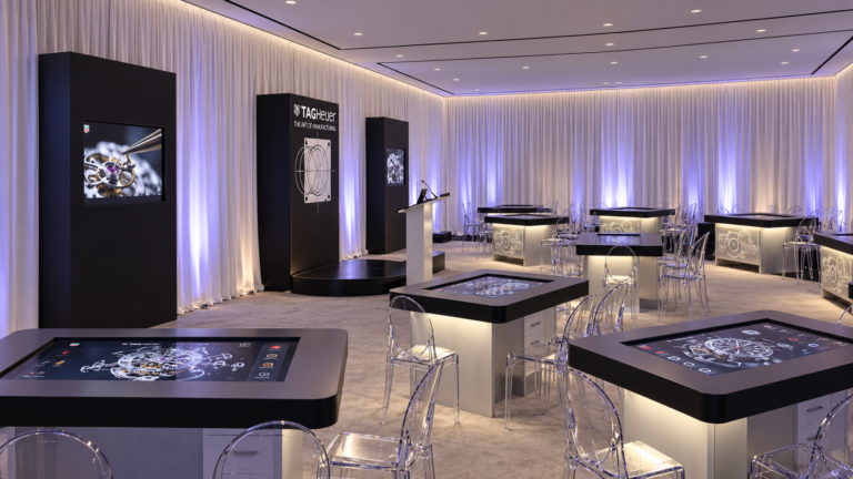 Enhanced visualization of the TAG Heuer Art of Manufacturing room, with interactive watchmaker stations and illuminated etched gears.